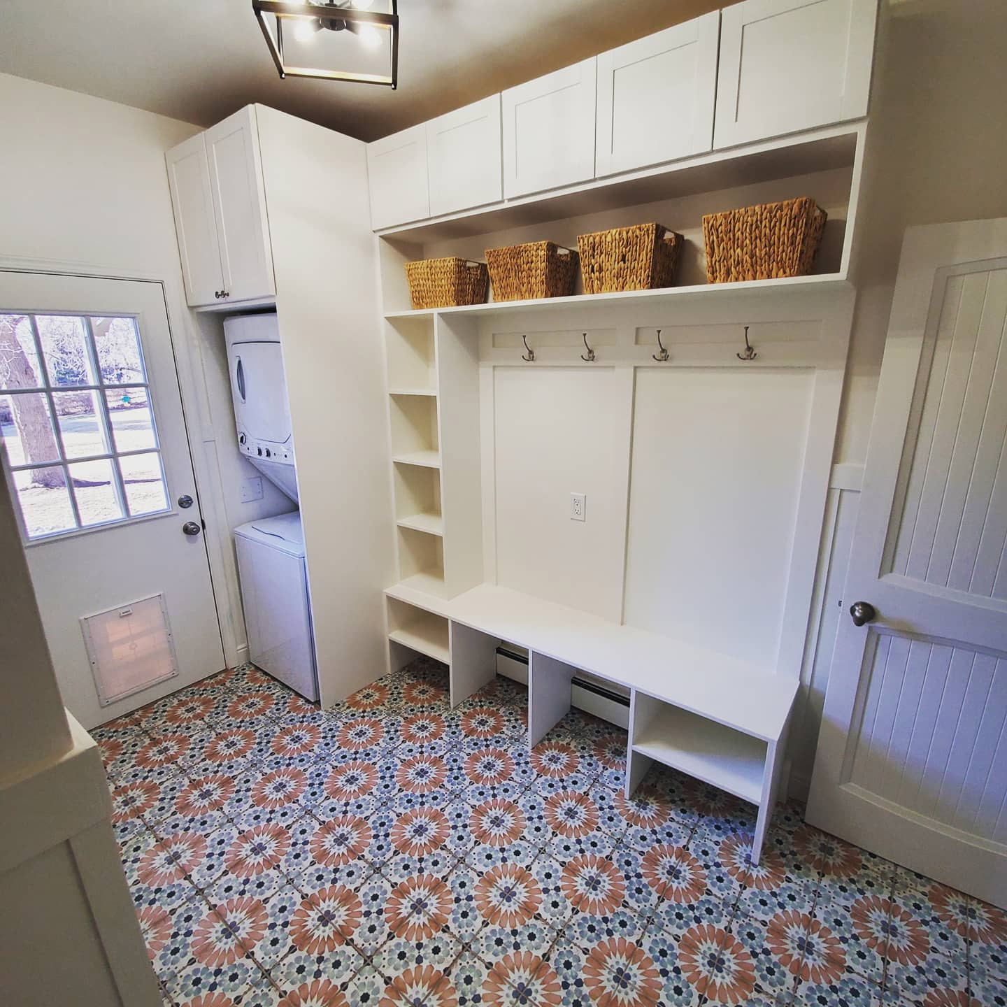 Custom mudroom built-in with cubbies, hooks, and decorative tile floor